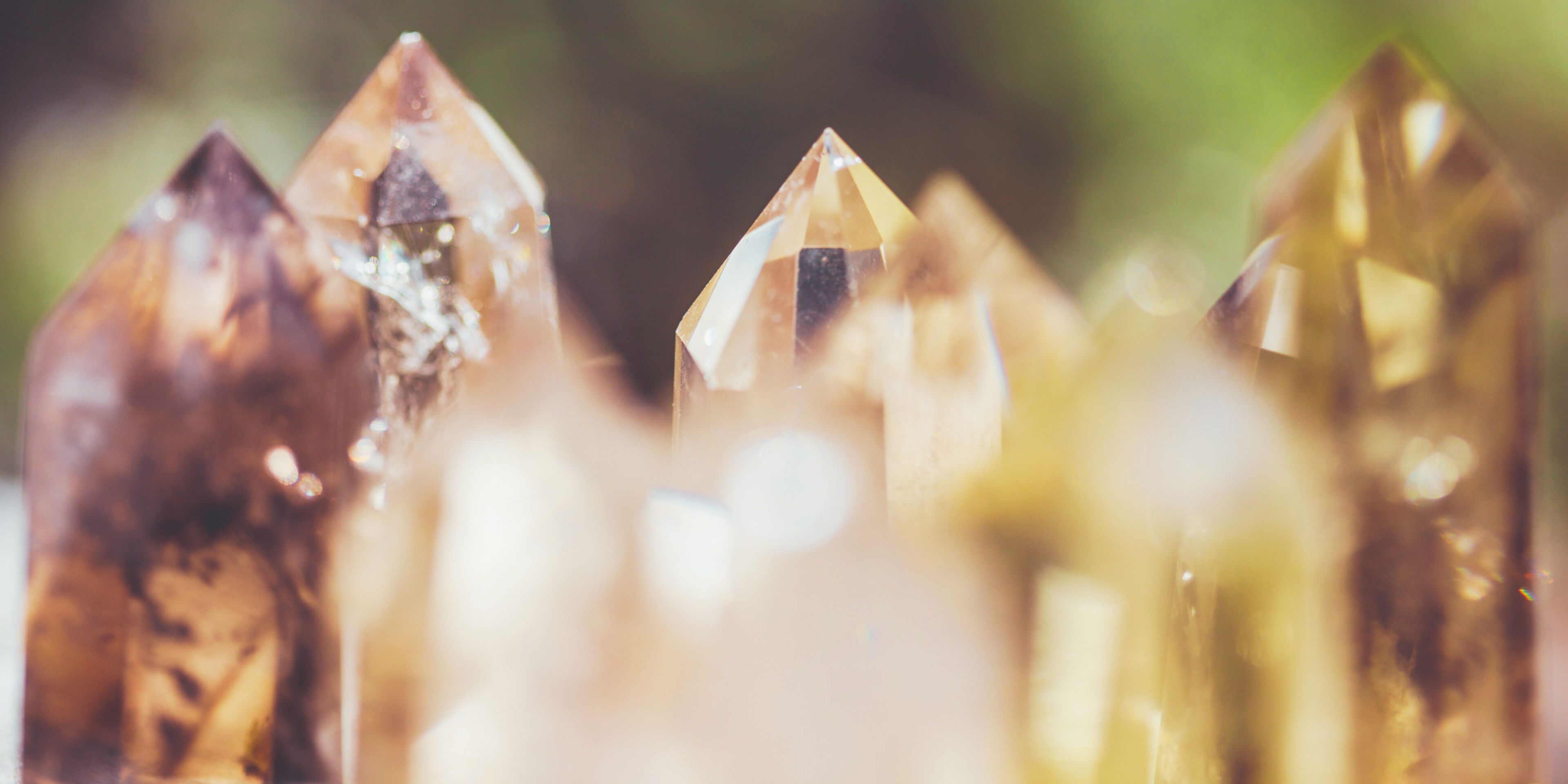 Close-up of ethically sourced smoky quartz crystal points glowing beautifully in natural sunlight.
